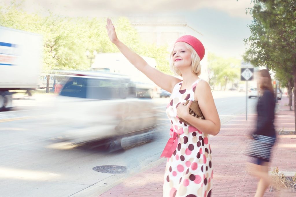 femme en tenue vintage cherchant un taxi