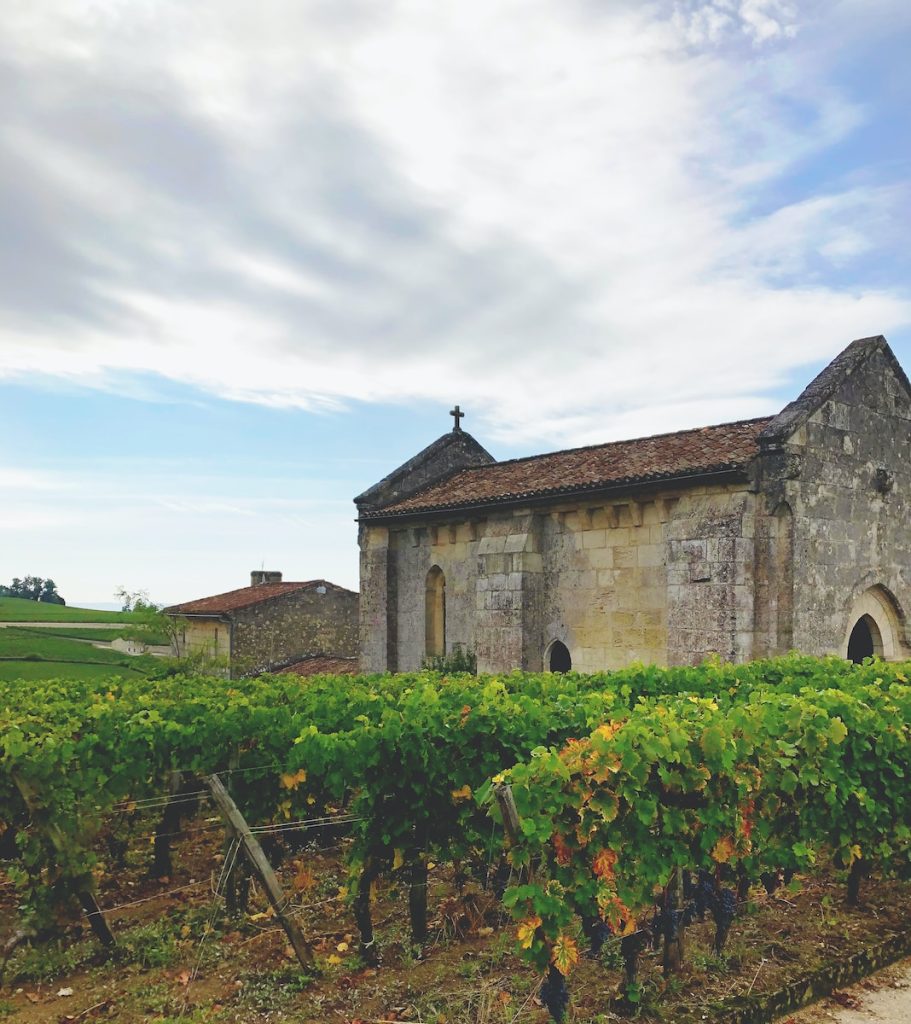 Une vieille église en pierre au milieu d'un vignoble.