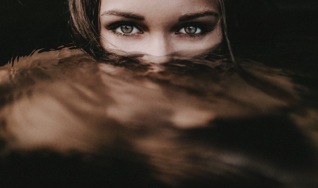 Le visage d'une femme dans l'eau aux yeux verts.