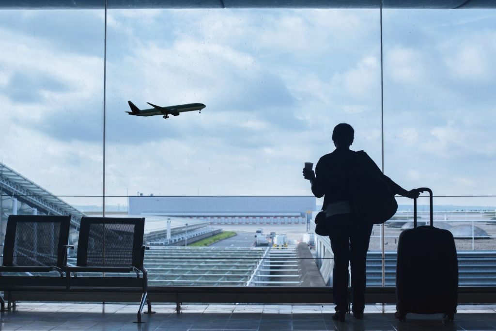 Une silhouette d’un homme debout dans un aéroport attendant un avion.