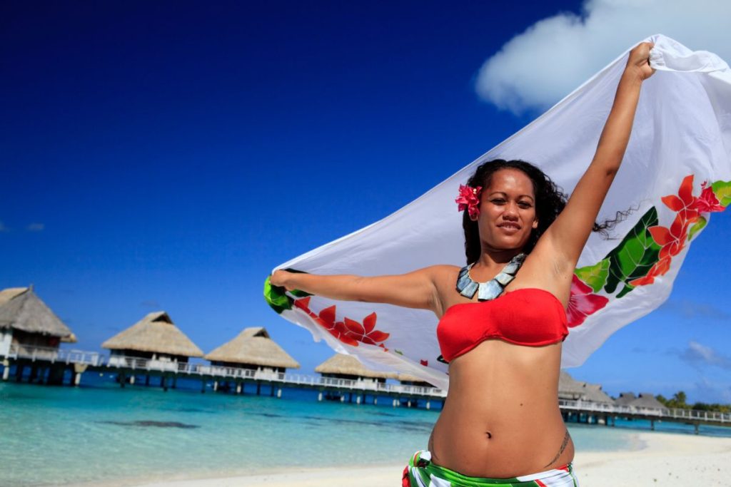 Une femme en bikini tenant une serviette sur la plage.