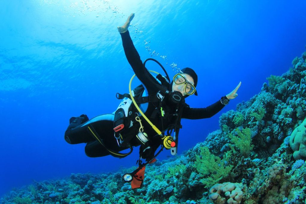 Une femme plongeant dans l'océan avec les bras tendus.