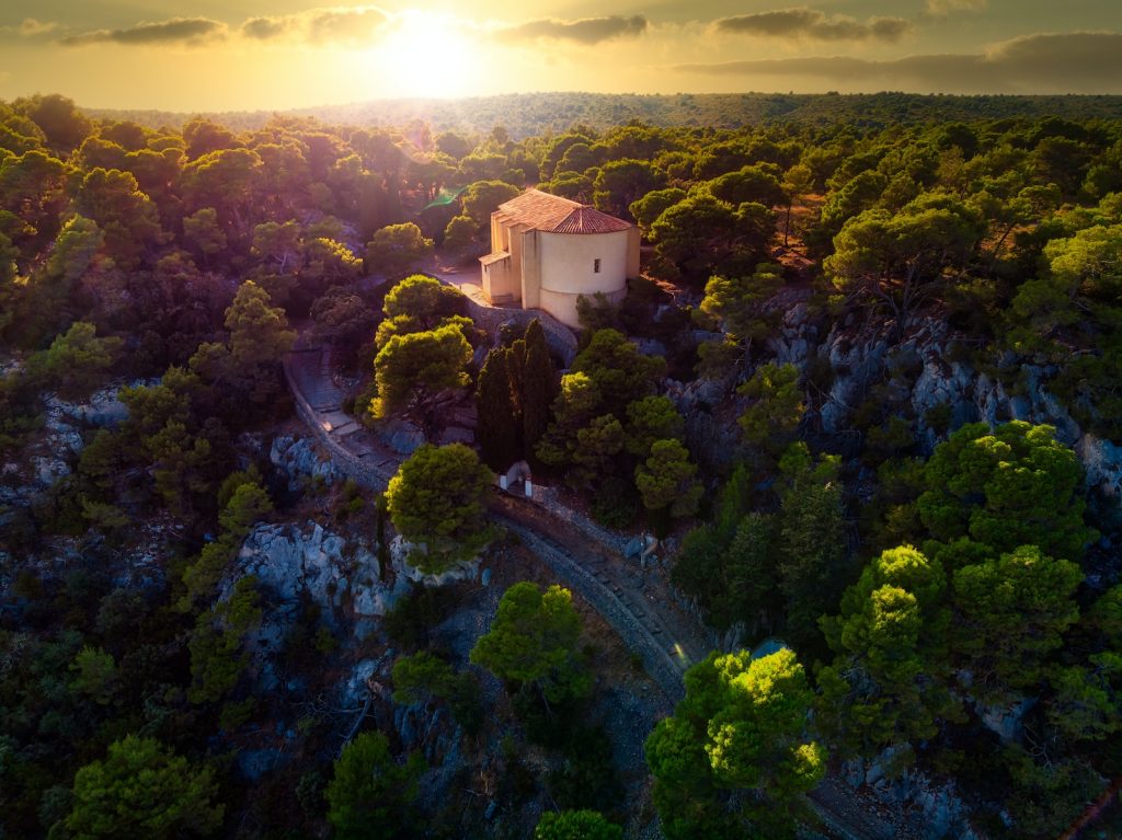 Une vue aérienne d'une église au milieu d'une forêt.