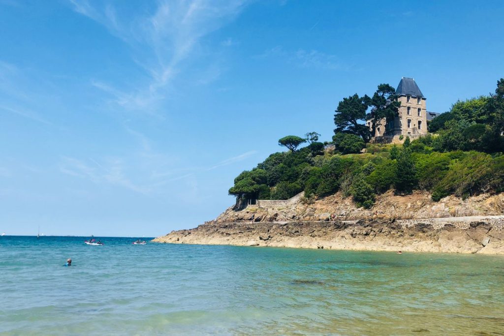 Un château se dresse au sommet d’une colline surplombant l’océan.