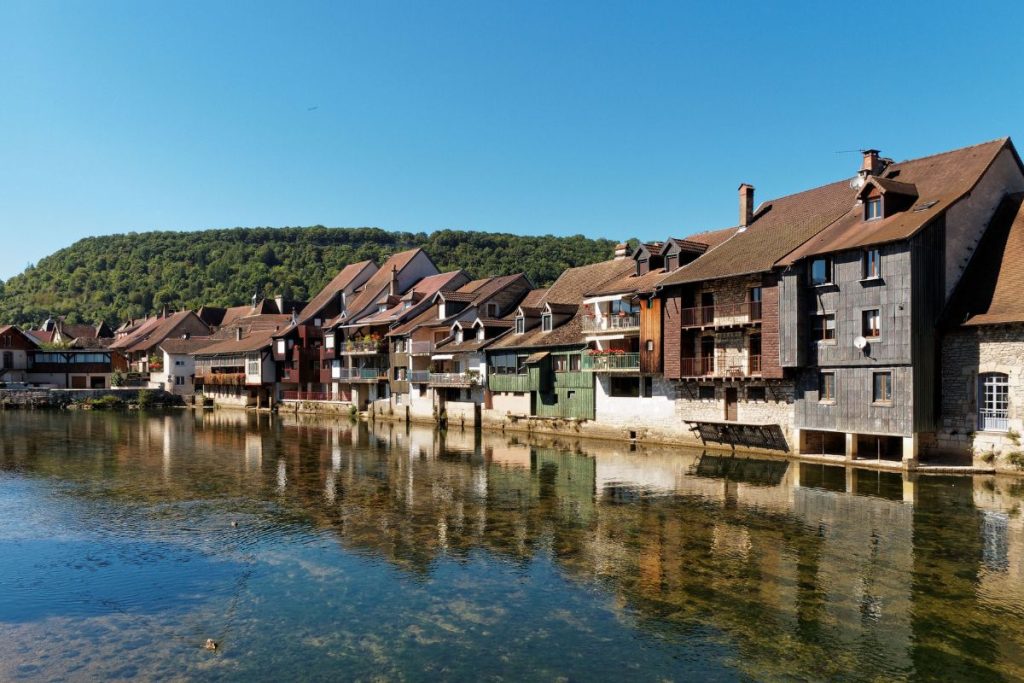 Une petite ville avec des maisons en bois au bord d'une rivière.
