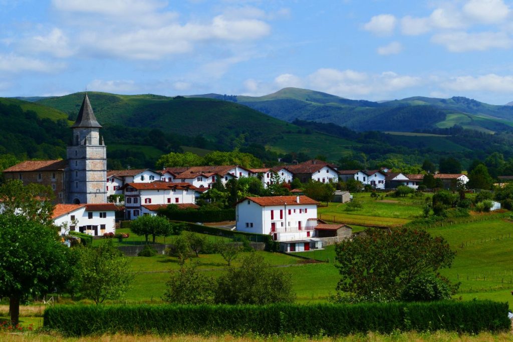 Un petit village avec une église au sommet d'une colline.