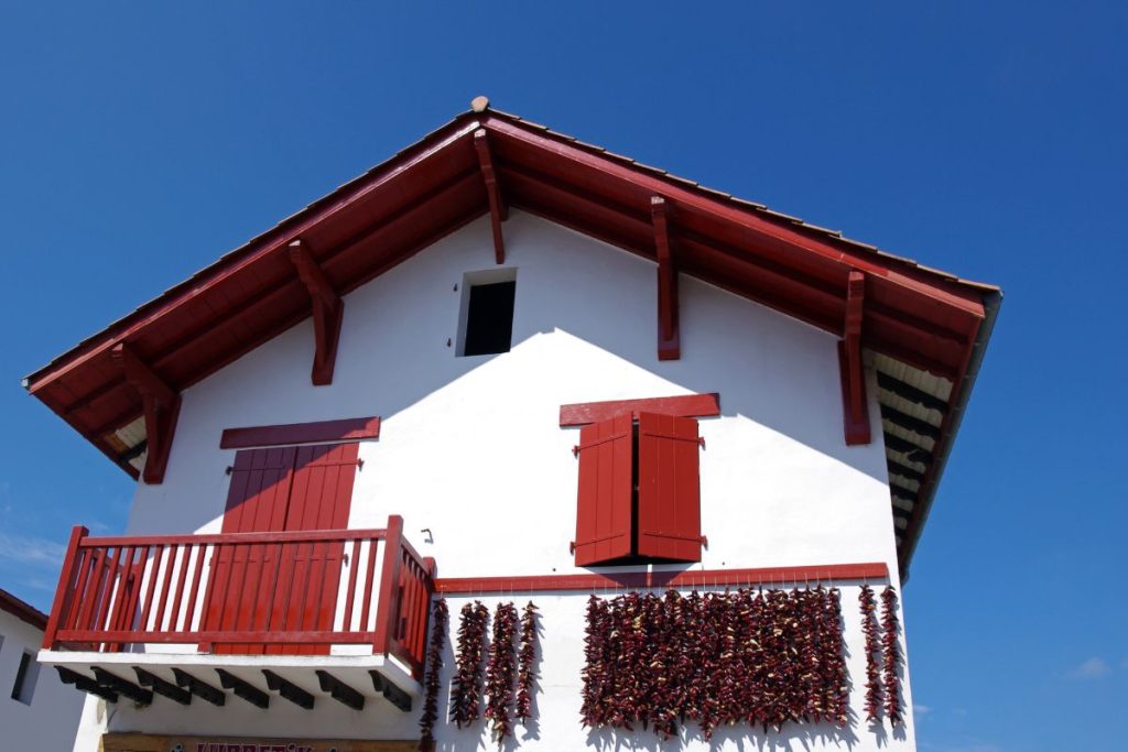 Un bâtiment blanc aux volets rouges.