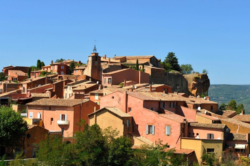 Un village aux bâtiments rouges au sommet d’une colline.