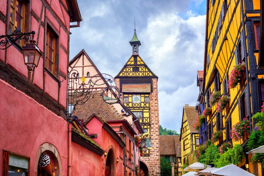 Une rue étroite avec des bâtiments colorés et une tour de l'horloge.