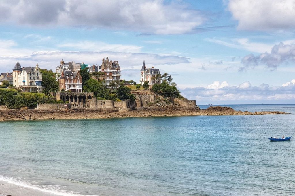 Un château se dresse au sommet d’une falaise rocheuse surplombant l’océan.