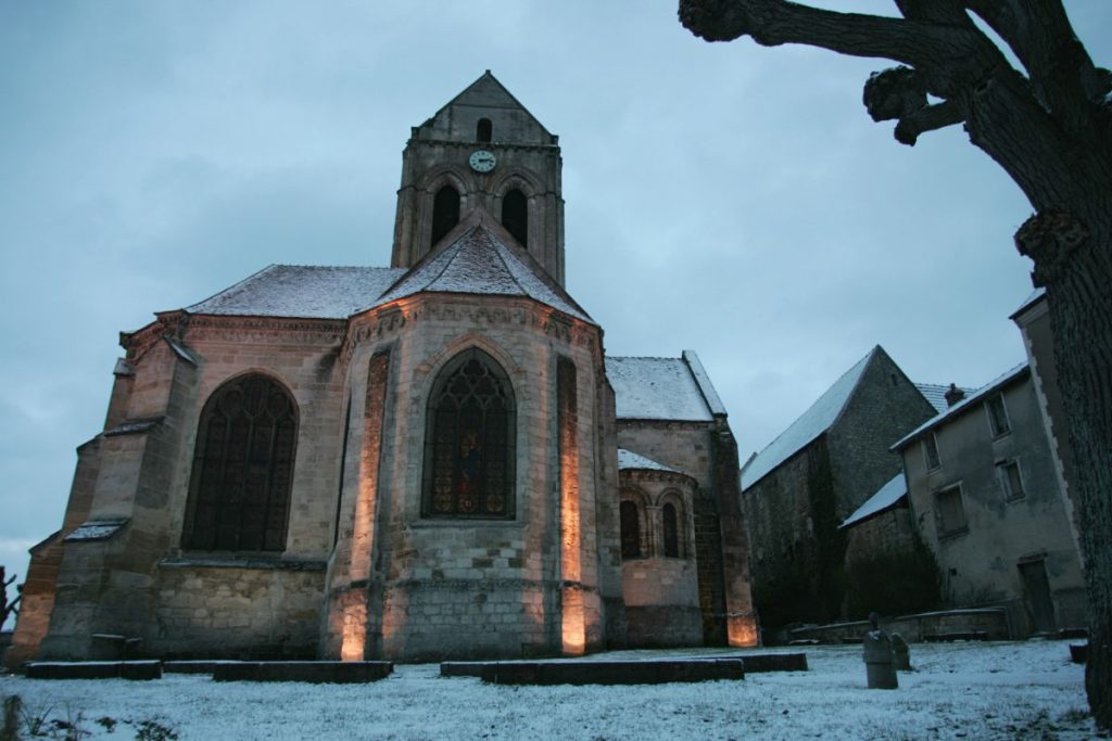 Une église est éclairée sous la neige.
