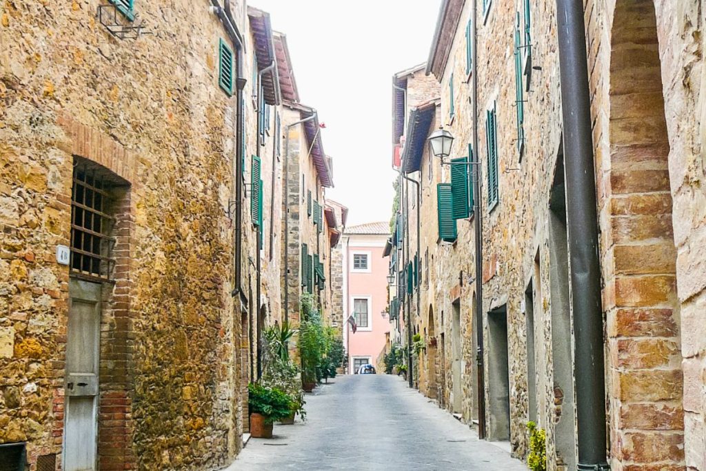 Une rue étroite bordée de bâtiments en pierre en Toscane.