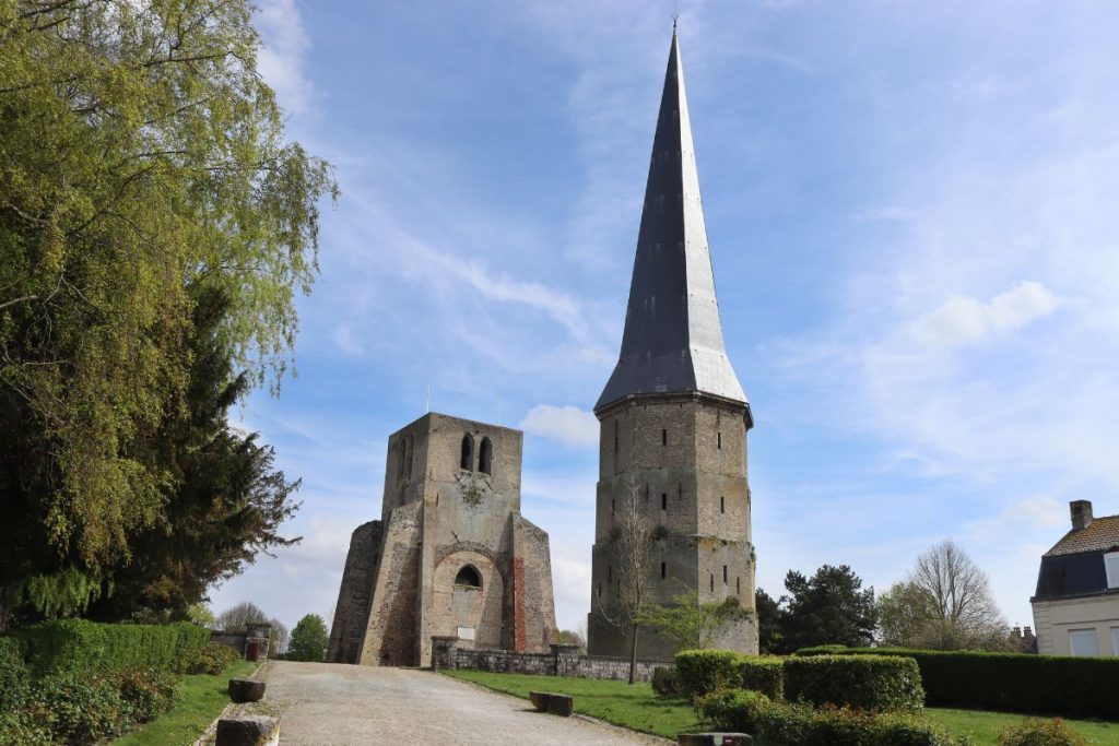 Une église avec un clocher devant.