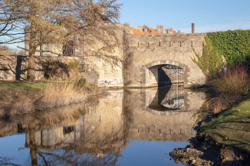 Un pont sur un canal avec un château en arrière-plan.