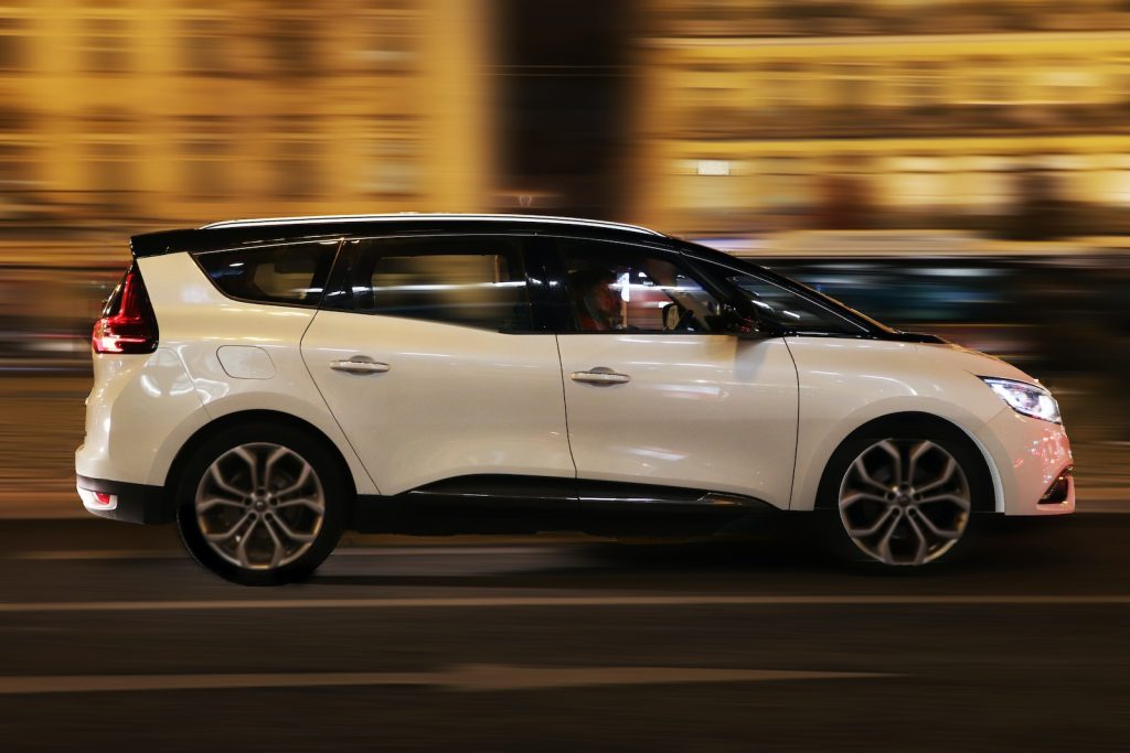 La Renault Clio blanche roule dans la rue la nuit.