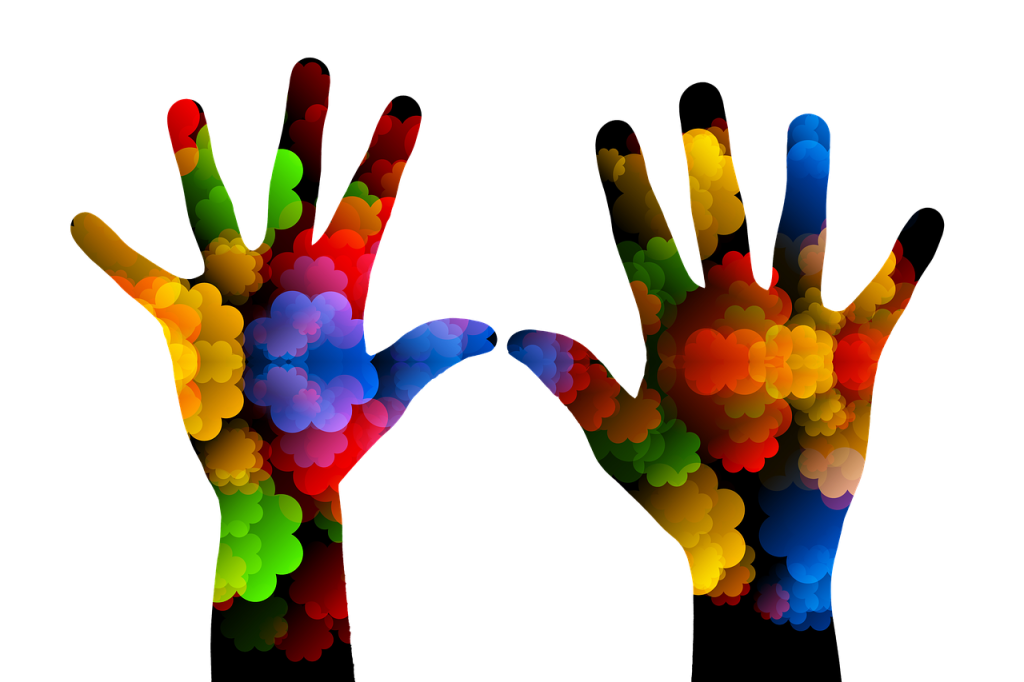 Une paire de mains avec des fleurs colorées dessus.