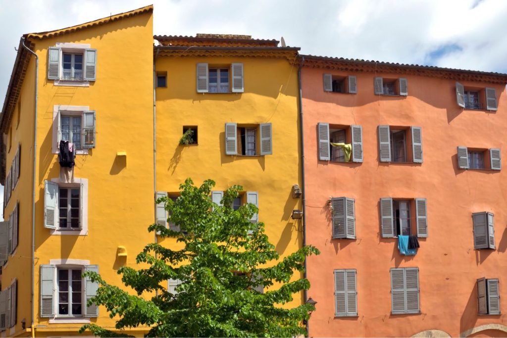 Un bâtiment coloré avec des volets aux fenêtres.