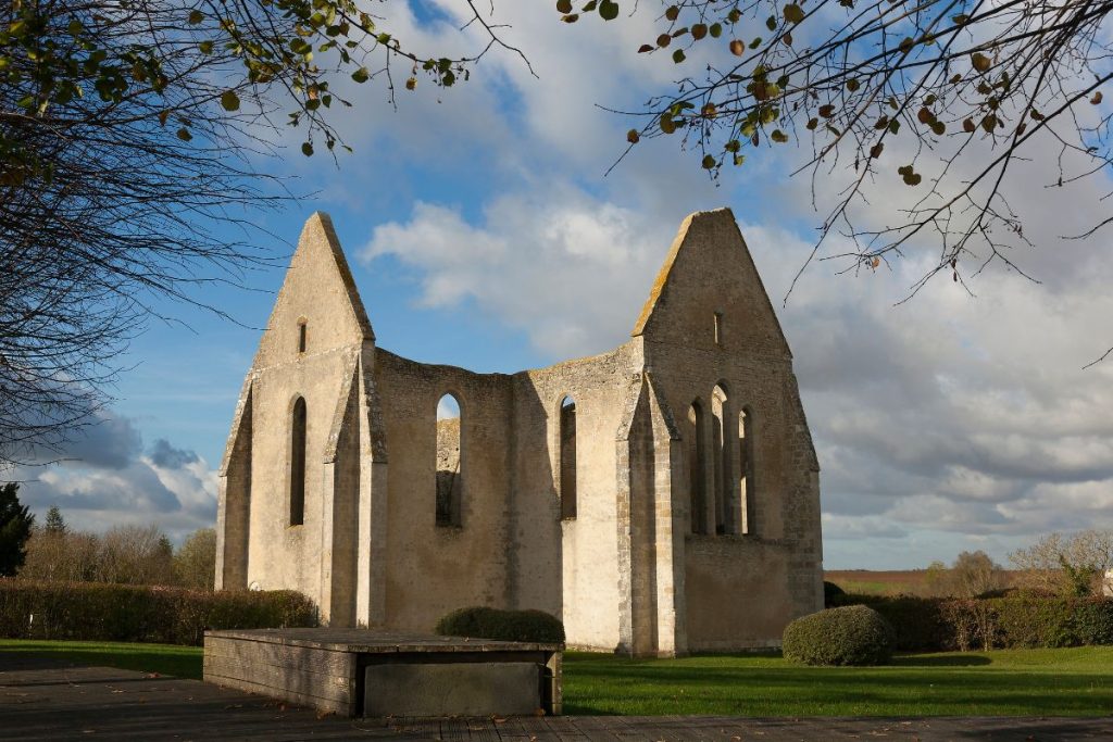 Une vieille église en pierre au milieu d'un champ herbeux.