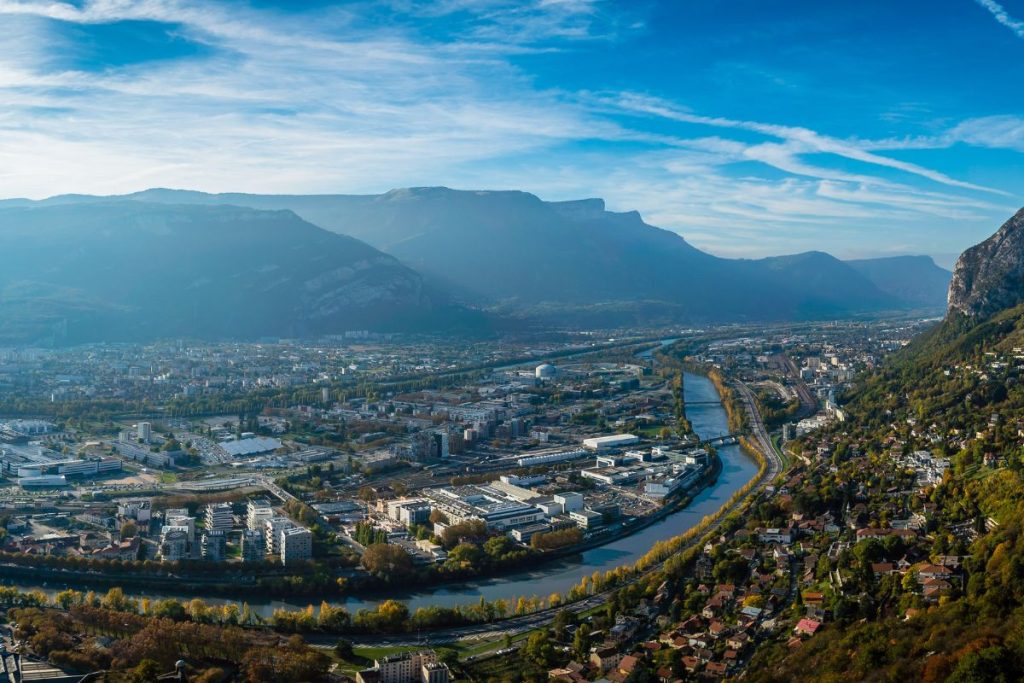Une vue d'une ville suisse avec des montagnes en arrière-plan.