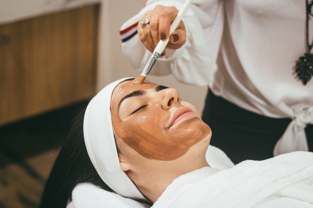 Une femme reçoit un soin du visage dans un spa.