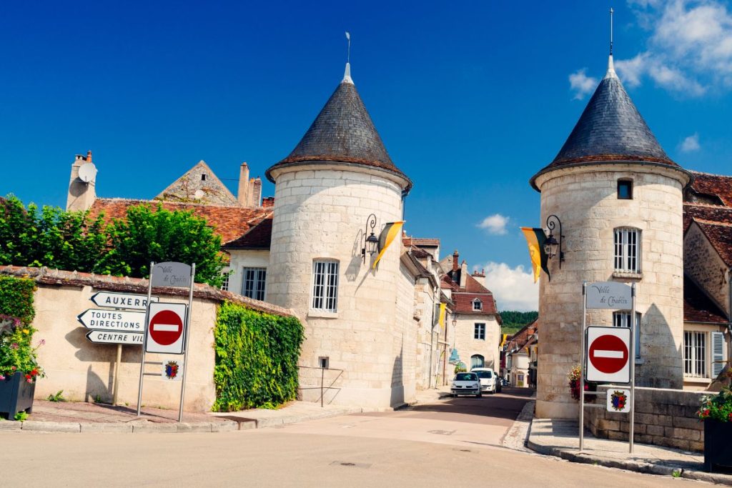 Une rue avec deux tours et un panneau de signalisation.