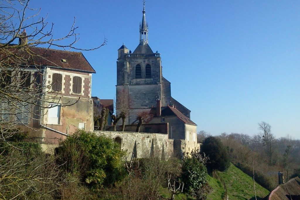 Une église avec un clocher au sommet d'une colline.
