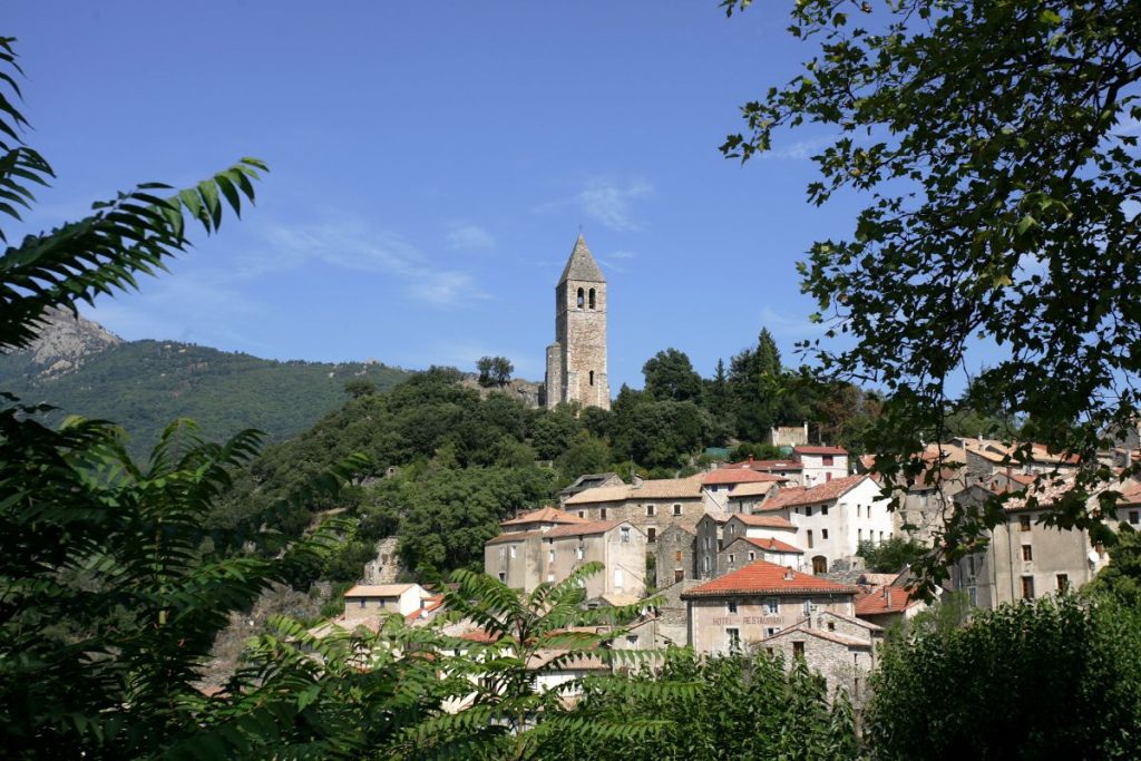 Une petite ville avec un clocher au sommet d'une colline.