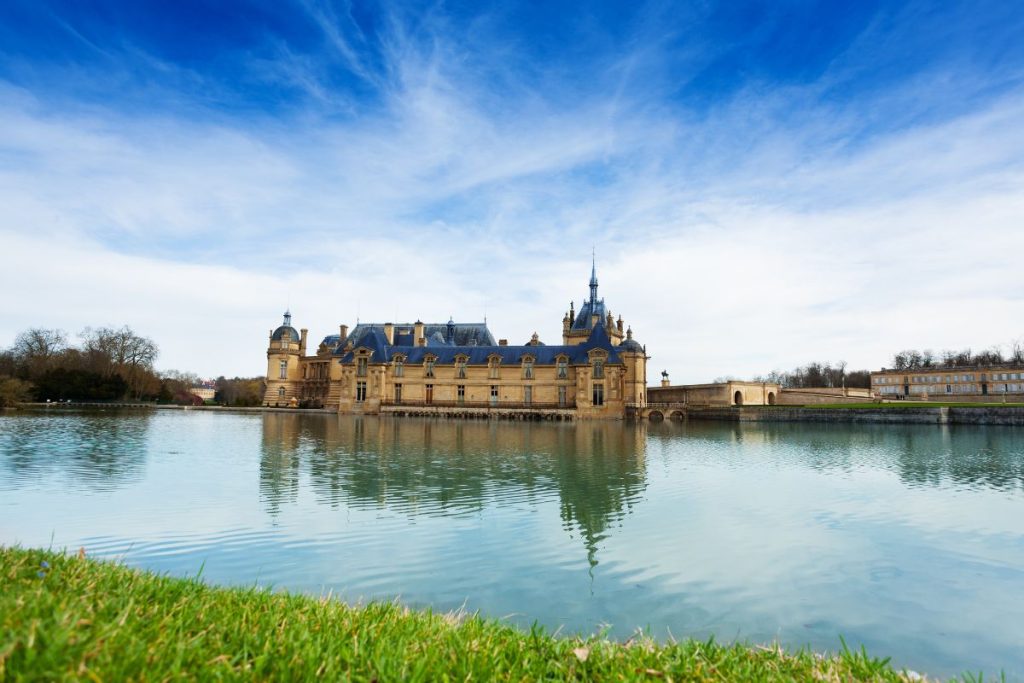 Un grand château se trouve à côté d'un lac.
