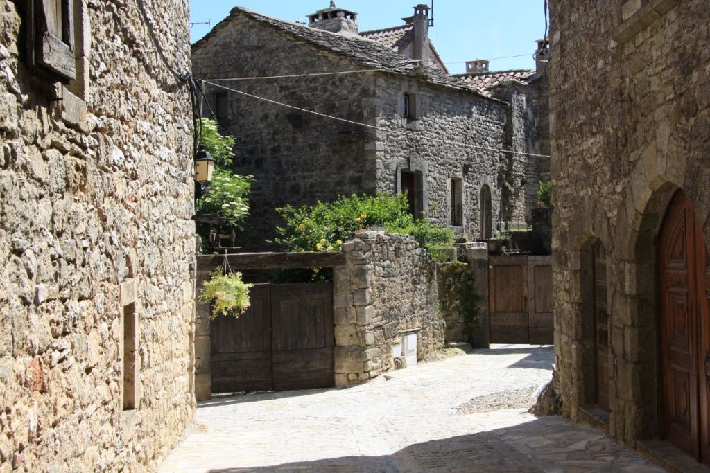 Ruelle pavée bordée de bâtiments traditionnels en pierre dans un village historique.