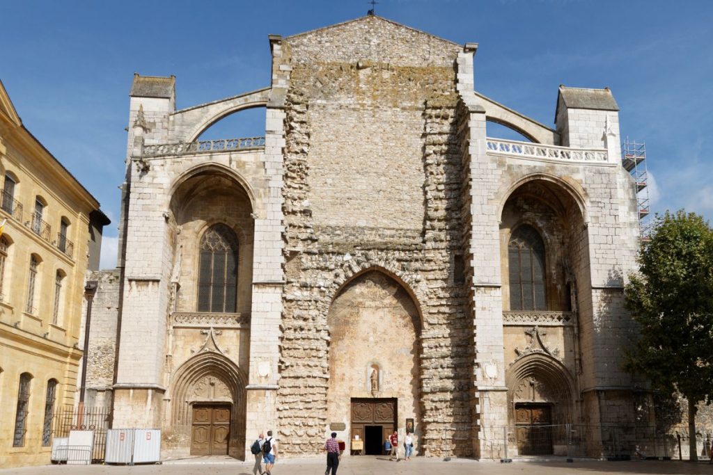 La façade de la cathédrale Saint-Maurice inachevée à Angers, en France, avec des piétons marchant devant.