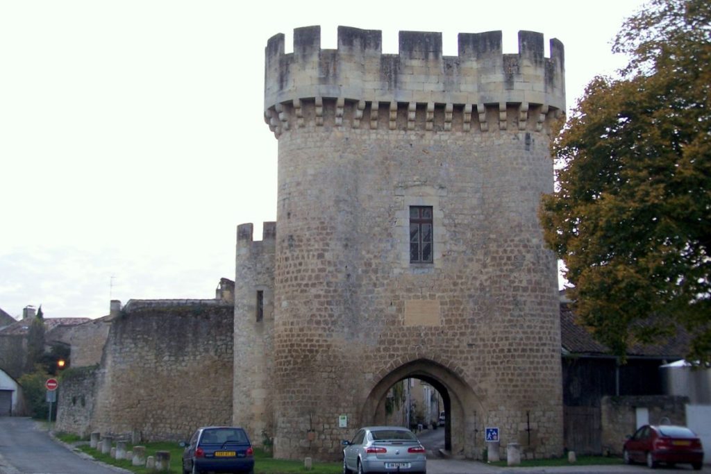 Corps de garde médiéval en pierre avec tour crénelée, faisant partie d'un ancien mur d'enceinte de la ville.