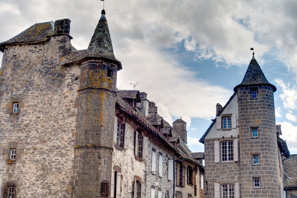 Bâtiments en pierre aux toits en forme de cône dans un quartier historique sous un ciel partiellement nuageux. Bâtiments en pierre aux toits en forme de cône dans un quartier historique sous un ciel partiellement nuageux.