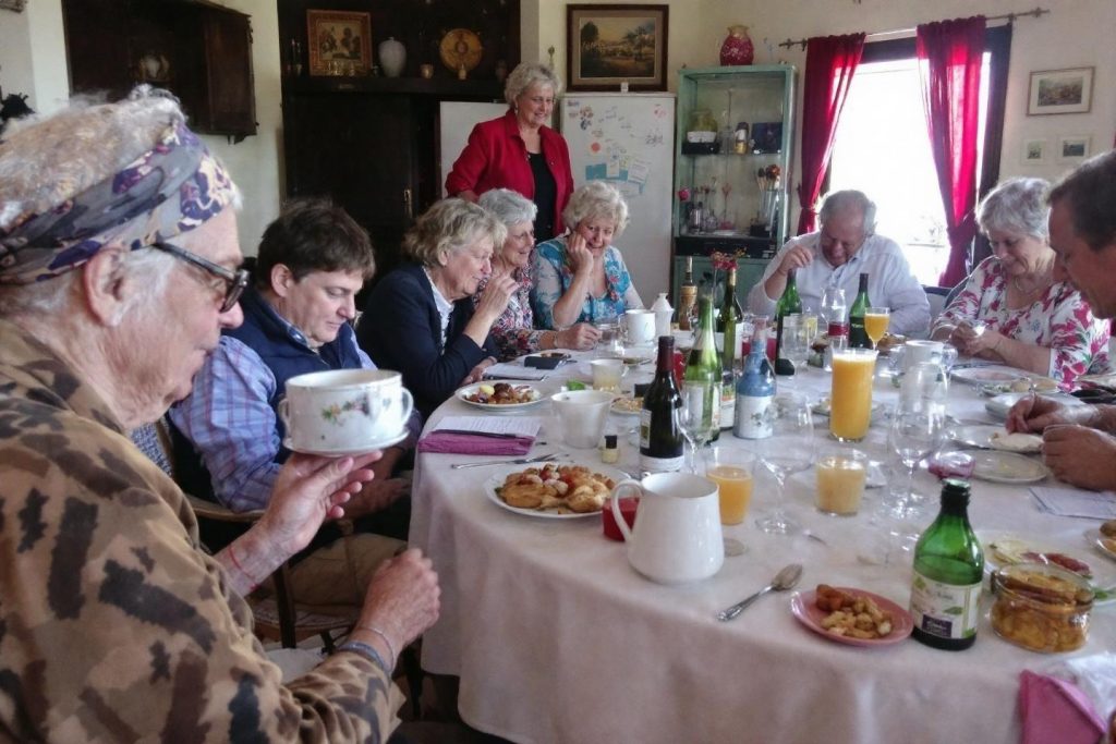Table de repas avec des seniors, boissons et nourriture