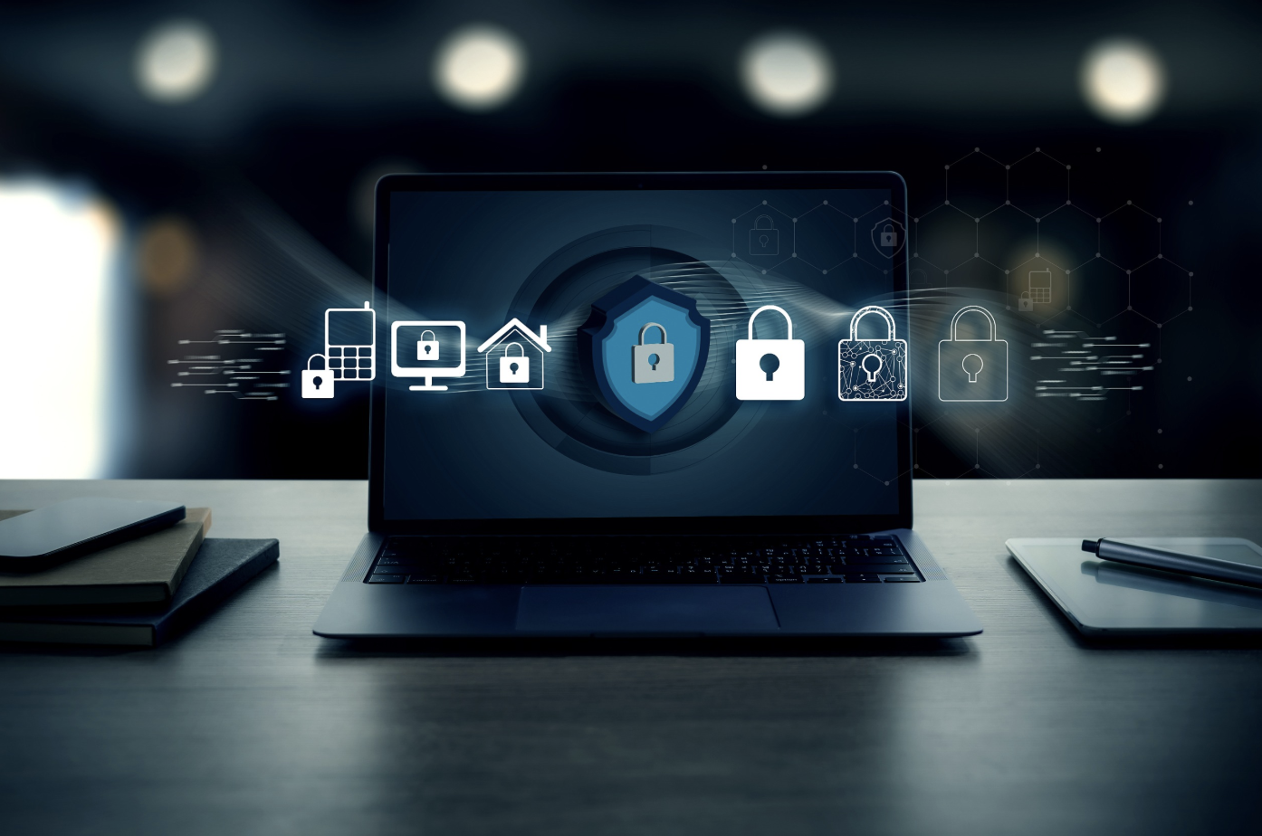 Un ordinateur portable affichant des icônes de cybersécurité, notamment des cadenas et des dispositifs connectés, symbolise la sécurité numérique et la protection des données sur un bureau où se trouvent des ordinateurs portables.