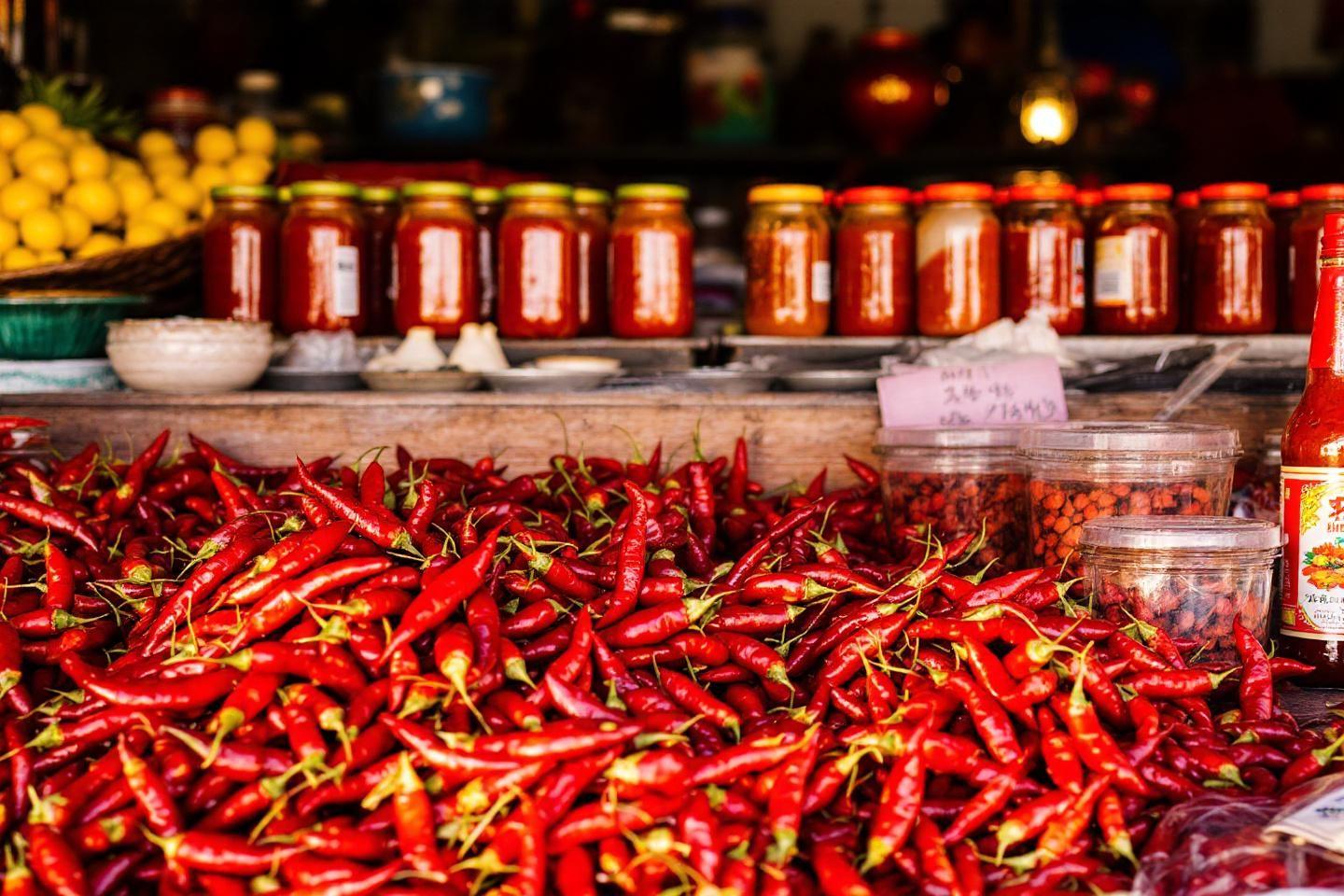Étalage de piments rouges frais avec bocaux de conserve