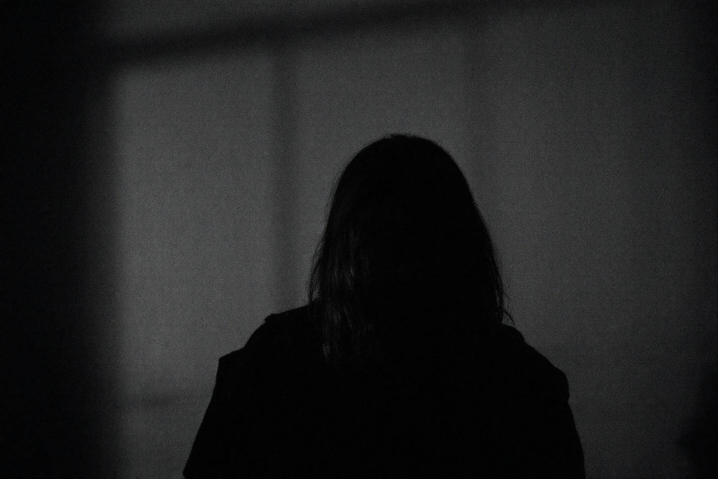 Forme humaine obscure de dos dans un environnement sombre