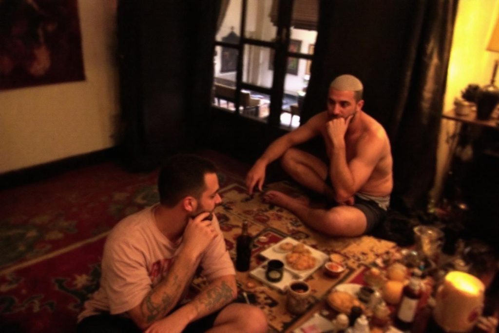 Deux hommes autour d'un plateau repas dans une ambiance tamisée