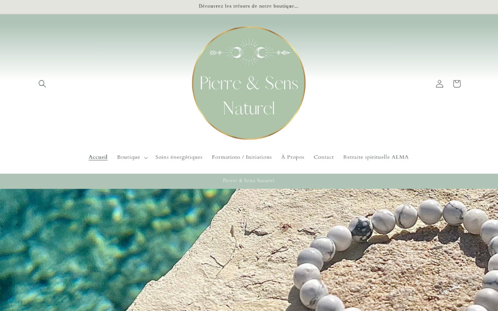 Page d'accueil du site Web de "Pierre & Sens Naturel" présentant un logo circulaire, un menu de navigation et une photo d'un bracelet de perles en pierre blanche sur une pierre ensoleillée au bord de l'eau.