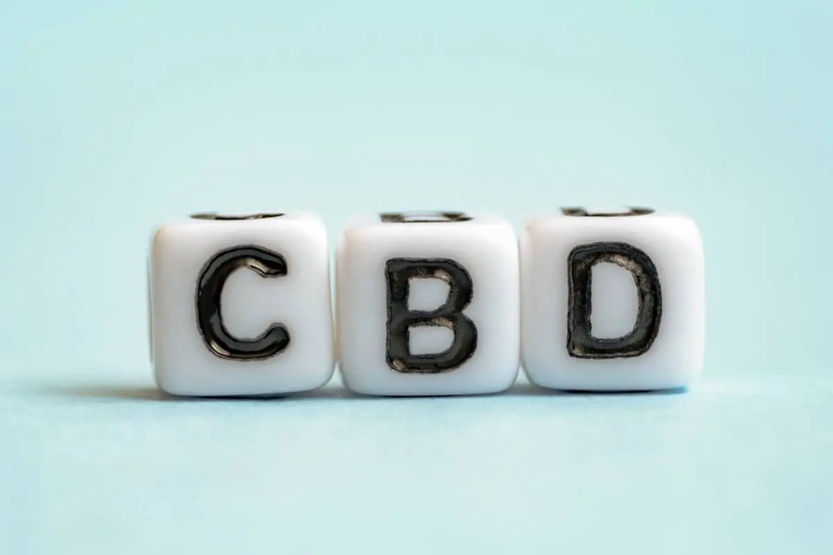 Trois dés blancs portent les lettres C, B et D en noir sur un fond bleu clair.